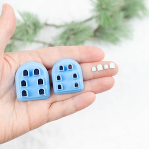 May include: Two blue plastic molds for making polymer clay or fondant decorations. The molds feature arched windows and are shown next to four light green arched window shapes.