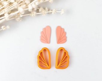 Peut inclure: Deux paires de boucles d'oreilles décoratives en forme de coquille. Une paire est de couleur pêche et l'autre paire est orange.