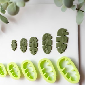 May include: Five green leaf-shaped silicone molds and five green leaf-shaped polymer clay pieces in various sizes.