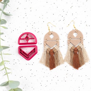 Peut inclure: Deux paires de boucles d'oreilles à franges beiges et brunes avec des formes géométriques. Les boucles d'oreilles sont en argile polymère et ont un crochet doré. Un moule en plastique rouge pour la fabrication des boucles d'oreilles est également présenté.