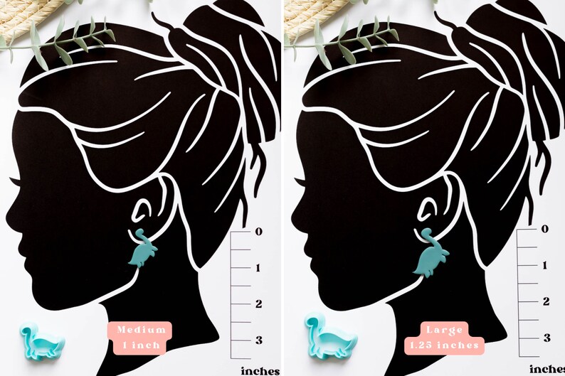 May include: Two silhouette images of a person with a dinosaur-shaped earring in one ear. The image on the left shows a medium-sized dinosaur earring measuring 1 inch. The image on the right shows a larger dinosaur earring measuring 1.25 inches.