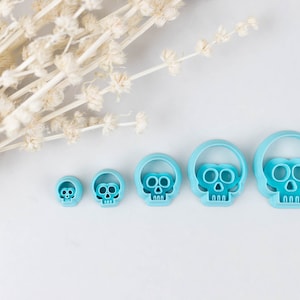 May include: Set of five blue plastic skull-shaped cookie cutters of varying sizes.