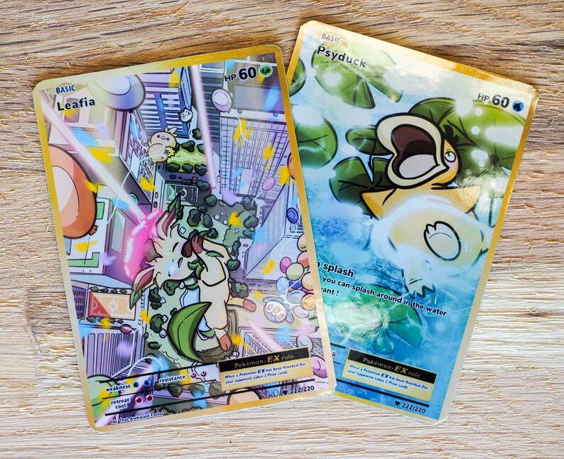 May include: Two Pokemon trading cards with gold borders. The card on the left is Leafia, a basic Pokemon with 60 HP. The card on the right is Psyduck, a basic Pokemon with 60 HP. Both cards feature colorful illustrations and text that includes the Pokemon's name, HP, and abilities. The Leafia card features a light pink and green Pokemon with a leafy tail. The Psyduck card features a yellow duck Pokemon with a blue background.