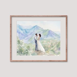 Puede incluir: Pintura a la acuarela de una pareja abraz&aacute;ndose, con un fondo de monta&ntilde;as azules y follaje verde. La novia lleva un vestido blanco y el novio un traje gris. La obra est&aacute; enmarcada en un marco de madera marr&oacute;n claro.