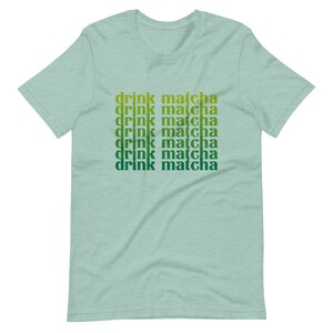 May include: A light green t-shirt with the text "drink matcha" repeated six times in a gradient of green and yellow.