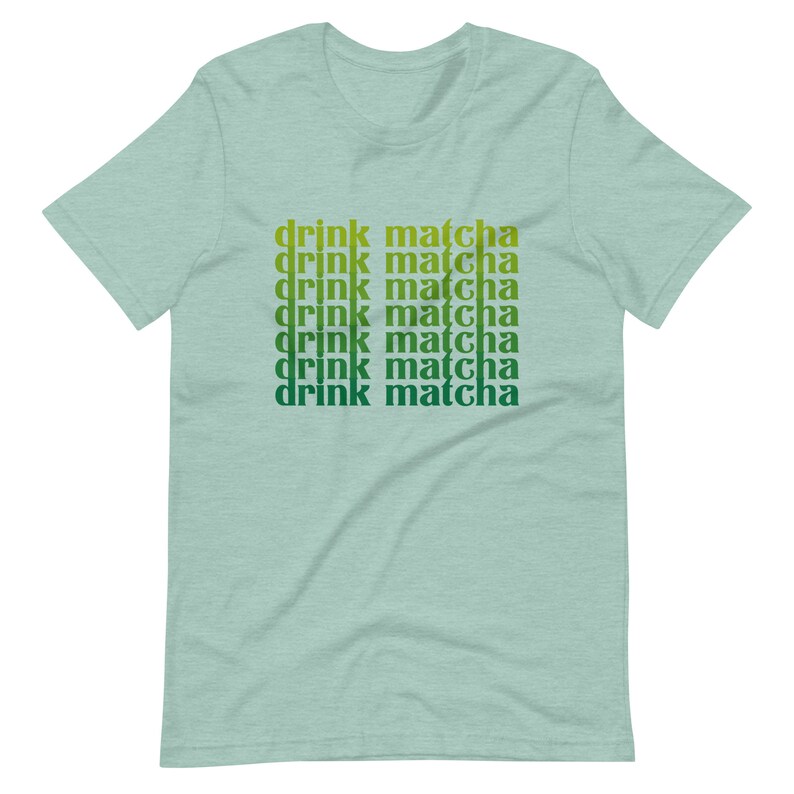 May include: A light green t-shirt with the text "drink matcha" repeated six times in a gradient of green and yellow.