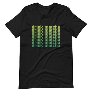 May include: Black t-shirt with the text "drink matcha" repeated in a gradient of green and yellow.