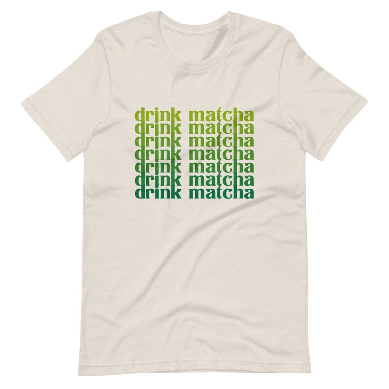 May include: A beige t-shirt with the text "drink matcha" repeated six times in a gradient of green and yellow.