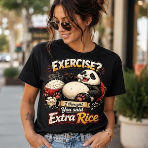 Könnte beinhalten: Ein schwarzes T-Shirt mit einer Grafik eines Pandas, der Reis mit Stäbchen isst. Der Text lautet EXERCISE? I thought You said Extra Rice. Das Design zeigt eine Reisschüssel, eine kleine Take-away-Box und eine Sojasaucenflasche im Cartoon-Stil.