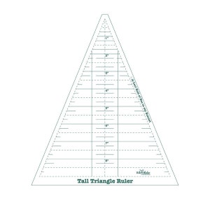 May include: A clear, triangular quilting ruler with green markings and the text "Tall Triangle Ruler." The ruler features inch measurements from 1" to 8" and is labeled with the text "Lori Holt of Bee in my Bonnet" and "Riley Blake Designs."