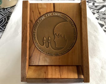 Puede incluir: Una caja de madera con una placa de latón que presenta un perfil de una persona con una luna creciente y velas. La placa dice "Arise For Thy Light Has Come Isaiah 60:1".