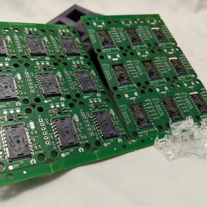 Puede incluir: Primer plano de varias placas de circuito impreso verdes con circuitos integrados negros y el texto "FINWALLS PCB REV 1.0".