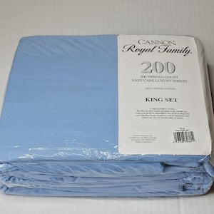 May include: A package of light blue Cannon Royal Family 200 thread count easy care luxury sheets in a king set. The plastic packaging features white labels with black text detailing the brand, thread count, and care instructions for the cotton.