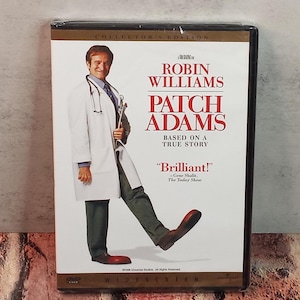 May include: DVD of the movie "Patch Adams" starring Robin Williams. The cover features Williams in a doctor's coat, with the film's title in large, bold letters. The DVD is labeled as a Collector's Edition.