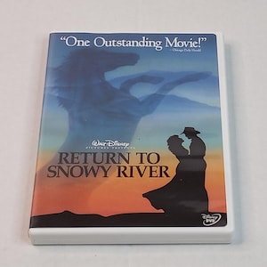 May include: A DVD case for "Return to Snowy River" with a silhouette of a couple and a horse against a sunset backdrop. The case has the Walt Disney Pictures logo and the text "One Outstanding Movie!" from the Chicago Daily Herald.