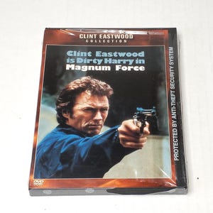 May include: A DVD case from the Clint Eastwood Collection featuring the film Magnum Force. The cover displays Clint Eastwood pointing a handgun, with the text Clint Eastwood is Dirty Harry in Magnum Force and Protected by Anti-Theft Security System.