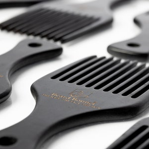 Pode incluir: Um conjunto de quatro pentes de madeira preta com um design de dentes largos. Os pentes t&ecirc;m uma pega arredondada e o texto "Beard Bonnet" est&aacute; gravado em um dos pentes.