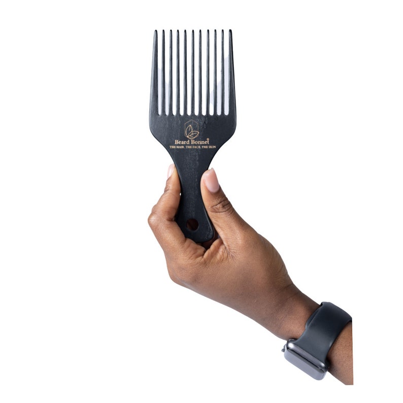 Pode incluir: Pente de barba de madeira preta com um logotipo dourado que diz "Beard Bonnet, The Hair, The Face, The Skin".