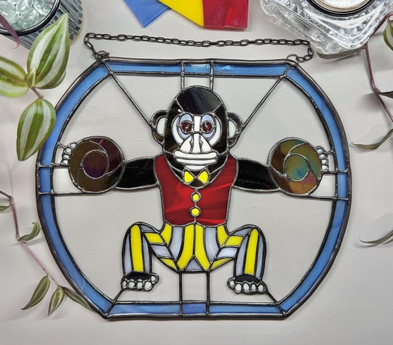 A full stained-glass circus monkey panel — genuine lead-and-solder craft that takes serious skill and looks like nothing else on a wall.