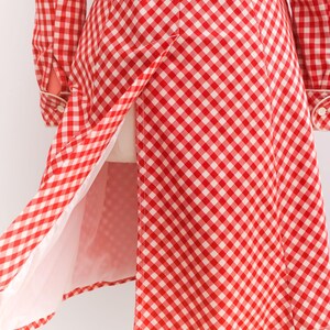 May include: A red and white gingham dress with a long sleeve and a belt. The dress has a white lining and a center back vent.