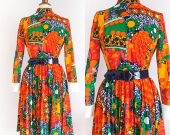 May include: A vintage 1960s mod dress with a colorful geometric print in shades of orange, green, and black. The dress has a high neck, long sleeves, and a pleated skirt.