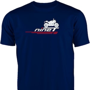 Könnte beinhalten: Ein marineblaues T-Shirt mit einer weißen Silhouette eines Motorrads und dem Text "nineT" in Rot und Weiß.