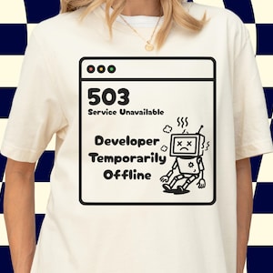 Könnte beinhalten: Cremefarbenes T-Shirt mit einer schwarz-weißen Grafik einer Computerfehlermeldung. Die Meldung lautet "503 Service Unavailable, Developer Temporarily Offline" mit einer traurigen Roboterillustration. Das Shirt hat kurze Ärmel.