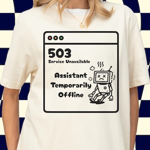 May include: Cream-coloured t-shirt with a black and white graphic depicting a computer error message. The message reads "503 Service Unavailable Assistant Temporarily Offline" with a cartoon robot character.