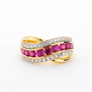 Könnte beinhalten: Ein goldener Ring mit einem wellenförmigen Design, das mit einer Reihe von rosafarbenen Edelsteinen und kleineren weißen Edelsteinen verziert ist.
