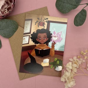 Carte postale Sorcière au Coffeeshop - Illustration de café et de livre - Cozy Witch DIN A6 - Cadeau pour les rats de bibliothèque et les amis sorciers