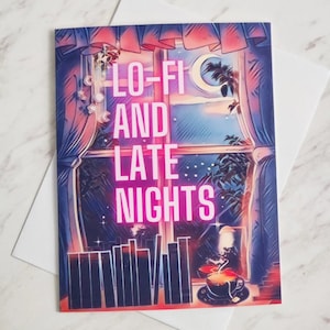 May include: Greeting card with a window scene, a crescent moon, and the text "LO-FI AND LATE NIGHTS" in pink. The image includes a cup of tea and a cityscape silhouette. The card is on a white envelope.