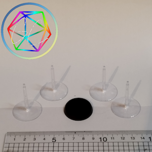May include: Four clear plastic bases with a small, clear plastic post in the centre. The bases are approximately 5 cm in diameter. There is also a black, round base that is approximately 5 cm in diameter.