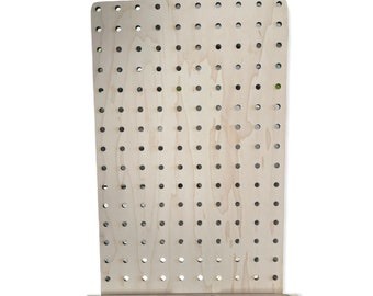 May include: A light wood pegboard with a shelf and the text "Busy Bear Crafts" on the front. The pegboard has a grid of evenly spaced holes.