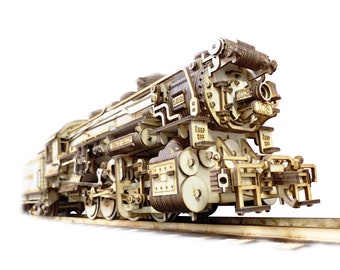 Può includere: Un modello in legno dettagliato di una locomotiva a vapore vintage con dettagli intricati, tra cui ruote, pistoni e un camino. Il modello è dipinto in tonalità di marrone e beige e presenta il testo "KEEP OFF" sul lato.
