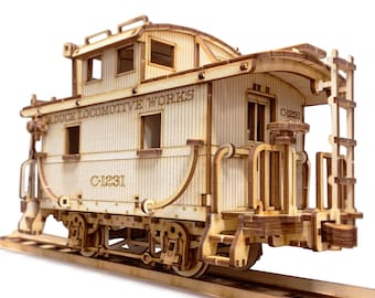 May include: Wooden model kit of a vintage train caboose with the text "Red Duck Locomotive Works" and "C-1231" on the side. The caboose has a ladder on the side and a small platform on the back.