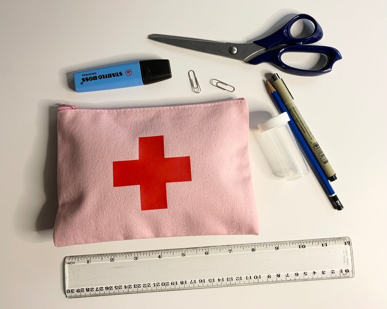 Puede incluir: Una bolsa de lona rosa con una cruz roja, un resaltador azul, tijeras, clips, l&aacute;pices, un peque&ntilde;o recipiente transparente y una regla marcada en cent&iacute;metros. La regla mide hasta 30 cm.
