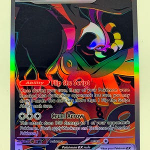 May include: A holographic Fezandipiti EX Pokémon trading card. The card features a colorful illustration of a creature with the text "Flip the Script" and "Cruel Arrow". The card has a HP of 210 and the number 092/064.