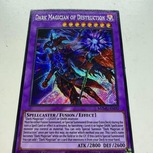 May include: A holographic trading card featuring "Dark Magician of Destruction" with a purple border. The card displays a detailed illustration of a dark wizard. Text includes card type, monster attributes, and attack/defense stats.