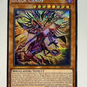 Puede incluir: Una carta coleccionable holográfica de Yu-Gi-Oh! titulada Black Chaos, que muestra un personaje hechicero con armadura oscura y un tocado puntiagudo, sosteniendo un bastón. La carta muestra el texto Spellcaster/Effect, ATK/3000, DEF/2500 y el código CORI-EN001.