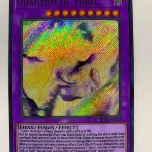 Peut inclure: Une carte de jeu de commerce holographique représentant un monstre violet foncé et noir avec un contour blanc. La carte est intitulée "Phantom of Yubel" et a un fond sombre avec un effet holographique. La carte est du jeu de cartes à collectionner "Yu-Gi-Oh!"