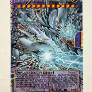 Peut inclure: Une carte à collectionner Yu-Gi-Oh! représentant Blue-Eyes Ultimate Dragon, the God-Surpassing Servant. La carte montre un dragon à trois têtes aux écailles bleues avec des effets d'éclairs, douze étoiles rouges et son effet de fusion.