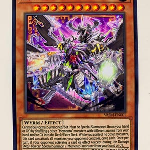 May include: A trading card for the game Yu-Gi-Oh! featuring a multi-colored monster with a skull-like head and wings. The card is called "Mementoal Tecuhtlica - Combined Creation" and has an attack and defense power of 5000. The card is from the Earth element.