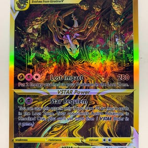 Puede incluir: Carta Pokémon Giratina VSTAR con diseño holográfico. La carta presenta una ilustración detallada de Giratina, con texto que incluye "Lost Impact" y "Star Requiem". La carta tiene 280 HP y es del set GG69/GG70.
