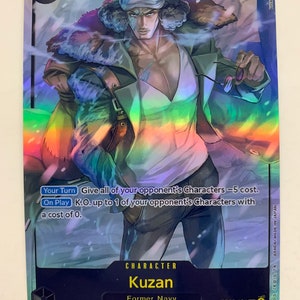 Może przedstawiać: Karta kolekcjonerska z postacią z anime One Piece. Postać to Kuzan, były członek Marynarki Wojennej. Karta jest holograficzna i ma niebiesko-białe tło. Karta ma poziom mocy 10 000 i specjalną umiejętność. Tekst na karcie brzmi: "Nadaj wszystkim postaciom przeciwnika -5 kosztów. Znokautować do 1 postaci przeciwnika z kosztem 0."
