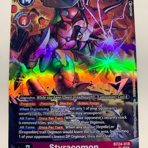 Peut inclure: Carte de jeu Digimon avec Styracomon, un Digimon de niveau Méga. La carte a une finition holographique avec un schéma de couleurs rouge, orange et vert. Le texte de la carte comprend les capacités Digivolve, Progress, Piercing, Blocker et Armor Purge.