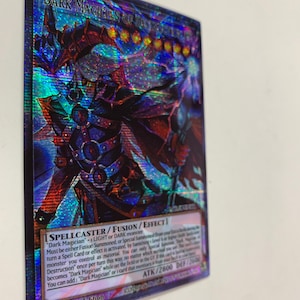 May include: A holographic trading card featuring "Dark Magician of Dark" with a detailed illustration of a character in dark armor. The card has text including "SPELLCASTER/FUSION/EFFECT" and "ATK/2800 DEF/2600".