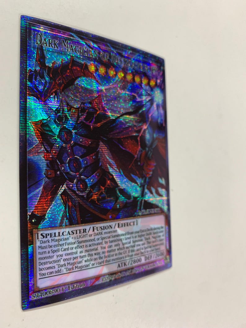 May include: A holographic trading card featuring "Dark Magician of Dark" with a detailed illustration of a character in dark armor. The card has text including "SPELLCASTER/FUSION/EFFECT" and "ATK/2800 DEF/2600".