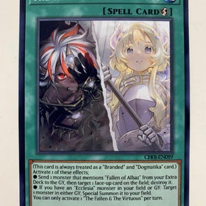 May include: A Yu-Gi-Oh! trading card titled "The Fallen & The Virtuous." The card features two anime-style characters, one dark and one light, split by a vertical line. The card has a green border and includes game text.