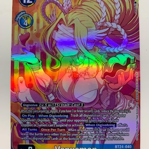 Peut inclure: Une carte à collectionner Digimon holographique représentant Venusmon. La carte présente une palette de couleurs or et violet avec le personnage Digimon au centre. La carte contient le texte "Venusmon" et d'autres informations de jeu.