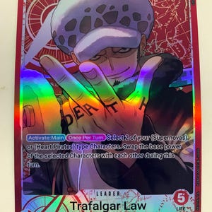 May include: A red trading card featuring Trafalgar Law from the One Piece series. The card displays a character illustration with a white and black hat, and a hand gesture with the word "DEATH" on the knuckles. The card has a 5000 power rating.